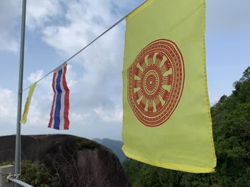 Low angle view of flags hanging against sky