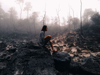 Man standing on rock in forest