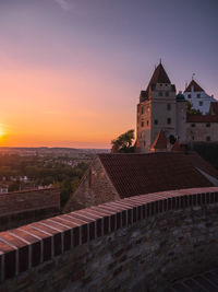 Buildings in city against sky during sunset