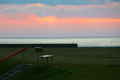 Chair on beach against sky