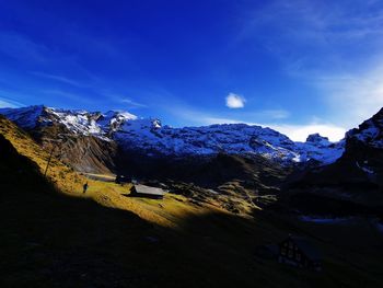 Scenic view of snowcapped mountains against blue sky