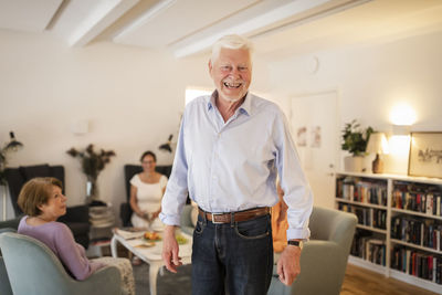 Portrait of happy senior man standing at nursing home