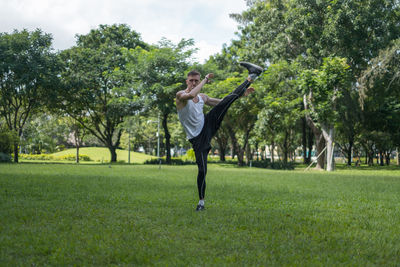 Full length of young man exercising on field