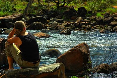 Rear view of woman standing on rock