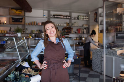 Portrait of a smiling young woman standing in store