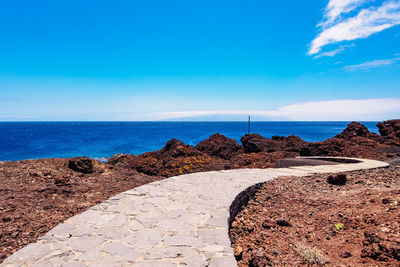 Scenic view of beach against blue sky