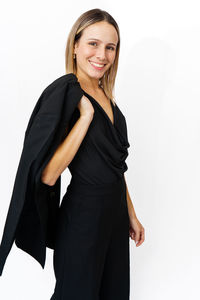 Portrait of young woman standing against white background