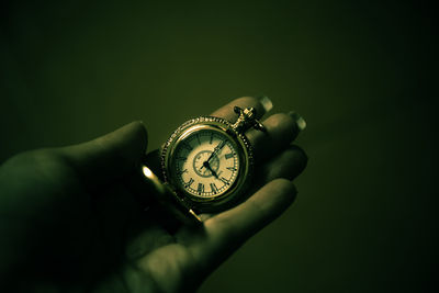 Close-up of hand holding clock