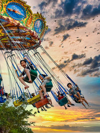 Low angle view of chain swing ride against sky