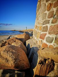 Rocks on beach against clear blue sky