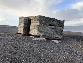 Old ruin on beach against sky