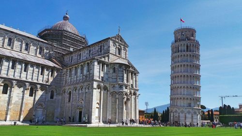 Piazza dei miracoli by leaning tower of pisa against sky