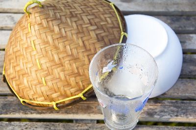 High angle view of glass with asian style conical hat on table