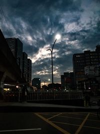 Street and buildings against sky at dusk