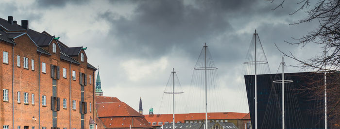 Low angle view of buildings against cloudy sky