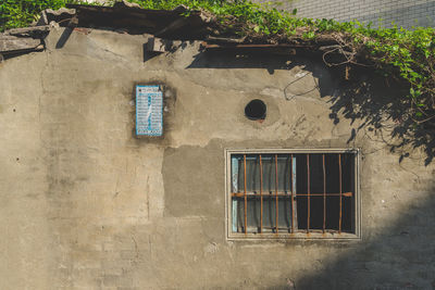 Close-up of window on wall during sunny day