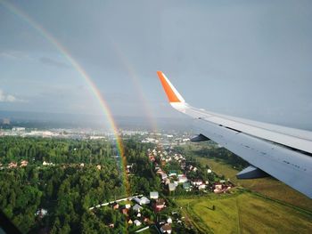 Aerial view of rainbow over landscape against sky