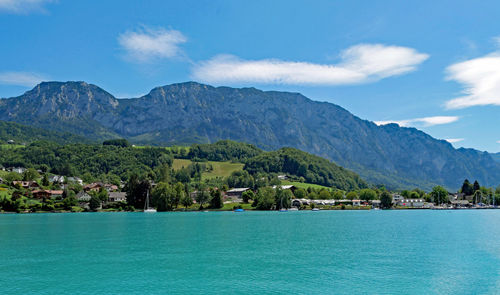 Scenic view of sea by mountains against sky