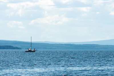 Boat sailing on sea against sky