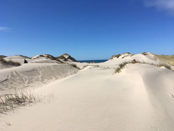 Scenic view of desert against clear blue sky