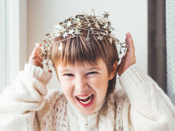 Smiling boy with christmas decoration on head at home