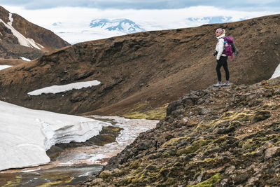 Female hiker standing beside glacial melt