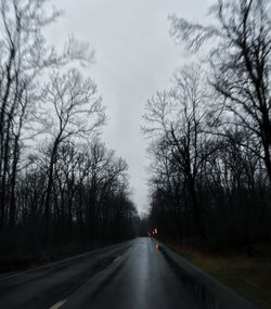 Road amidst trees against sky