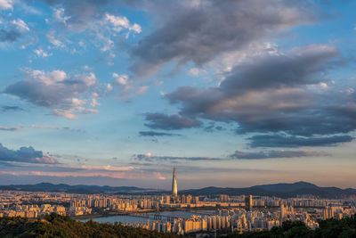 Buildings in city against cloudy sky