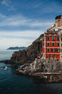 Sea by buildings against sky