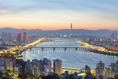 Illuminated buildings in city against sky