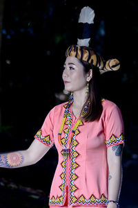 Close-up of young woman looking away standing outdoors