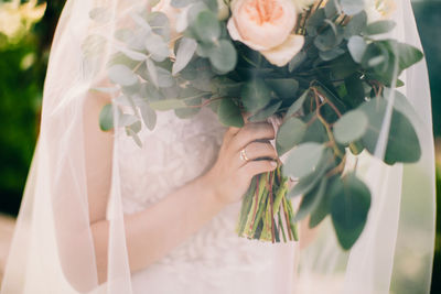 Midsection of woman holding flower bouquet