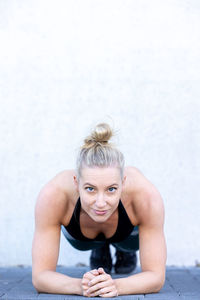 Attractive sporty perfect shaped blonde woman in gym while doing plank fitness exercises