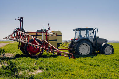 Tractor on field against clear sky