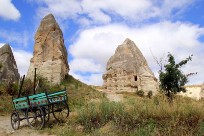 The view on the valley in the mountains with a cart on the foreground.