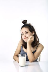 Portrait of young woman sitting with drink