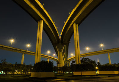 Low angle view of illuminated bridge against sky at night