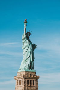 Low angle view of statue of liberty against blue sky