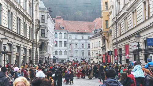 People walking on street amidst buildings in city