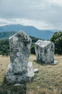 Stone wall in cemetery against sky