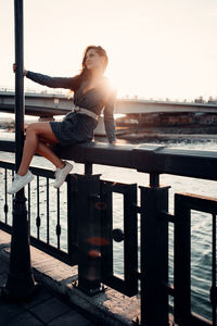 Woman on railing against sky