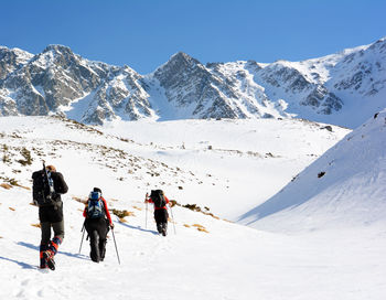 People on snowcapped mountain against sky