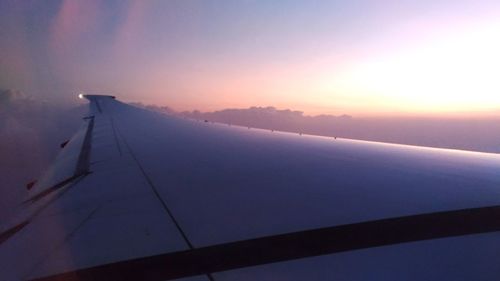 Close-up of wind turbine against sky during sunset