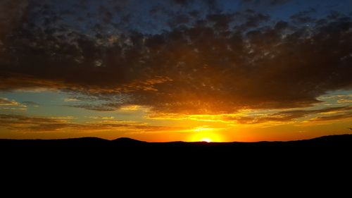 Silhouette landscape against sky during sunset