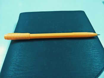 High angle view of pencil on table against blue background
