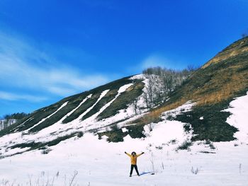 Man standing on snow covered landscape against sky