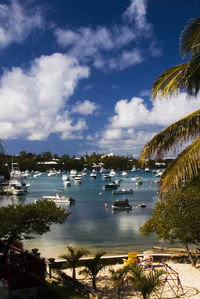 Boats in sea against cloudy sky