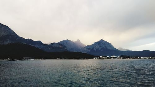 Scenic view of lake by mountains against sky