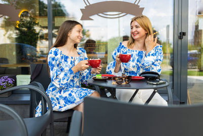 Portrait of smiling friends sitting at restaurant