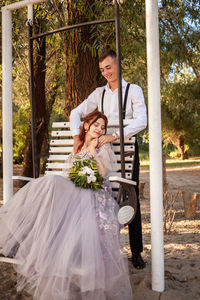 Wedding couple in the woods on a white swing. young people in love love with each other.
